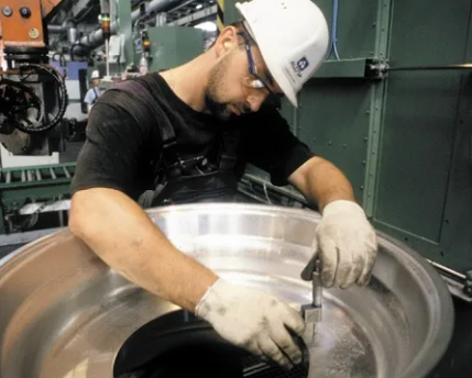 Profissional a trabalhar numa jante de alumínio Alcoa Wheels